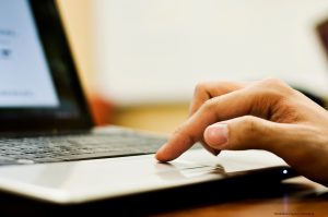tudent's finger on trackpad of computer.