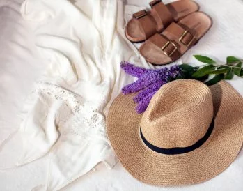beach sandals, hat, and lavender sitting on a bed