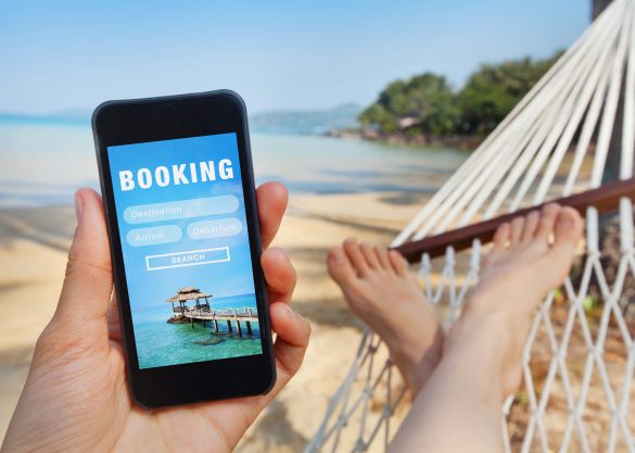 Person with phone in hammock booking a vacation