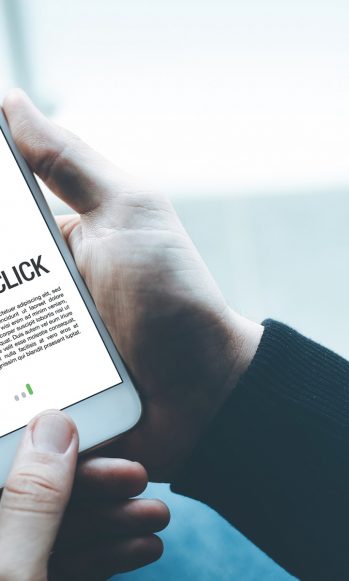 Person holding a mobile phone with an image that reads pay per click