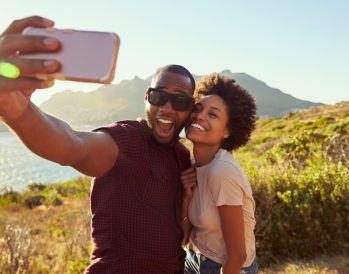 Couple taking a selfie with mountains behind them