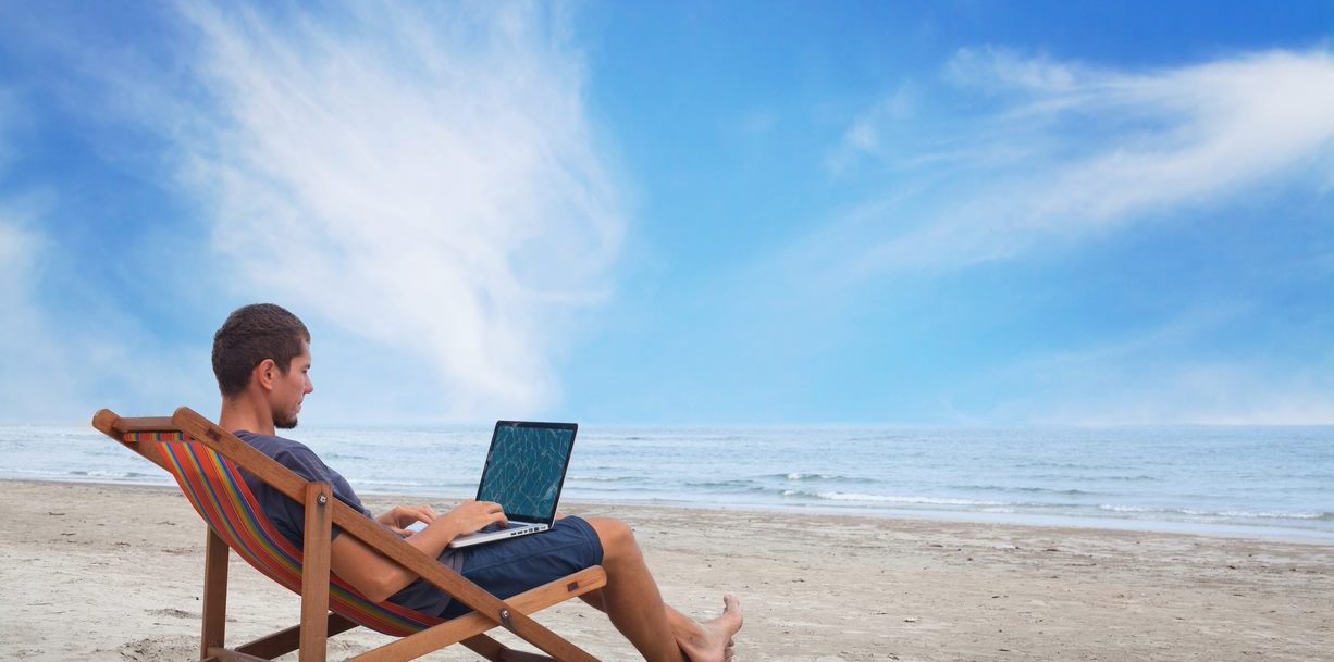 how to market your properties for workcations, man working from beach