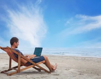 how to market your properties for workcations, man working from beach