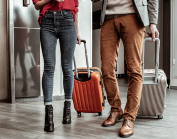 Stylish details. Charming girl wearing high-heeled shoes while walking with her partner