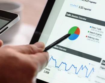 Pointing at graph on Google Analytics, researching keywords for SEO